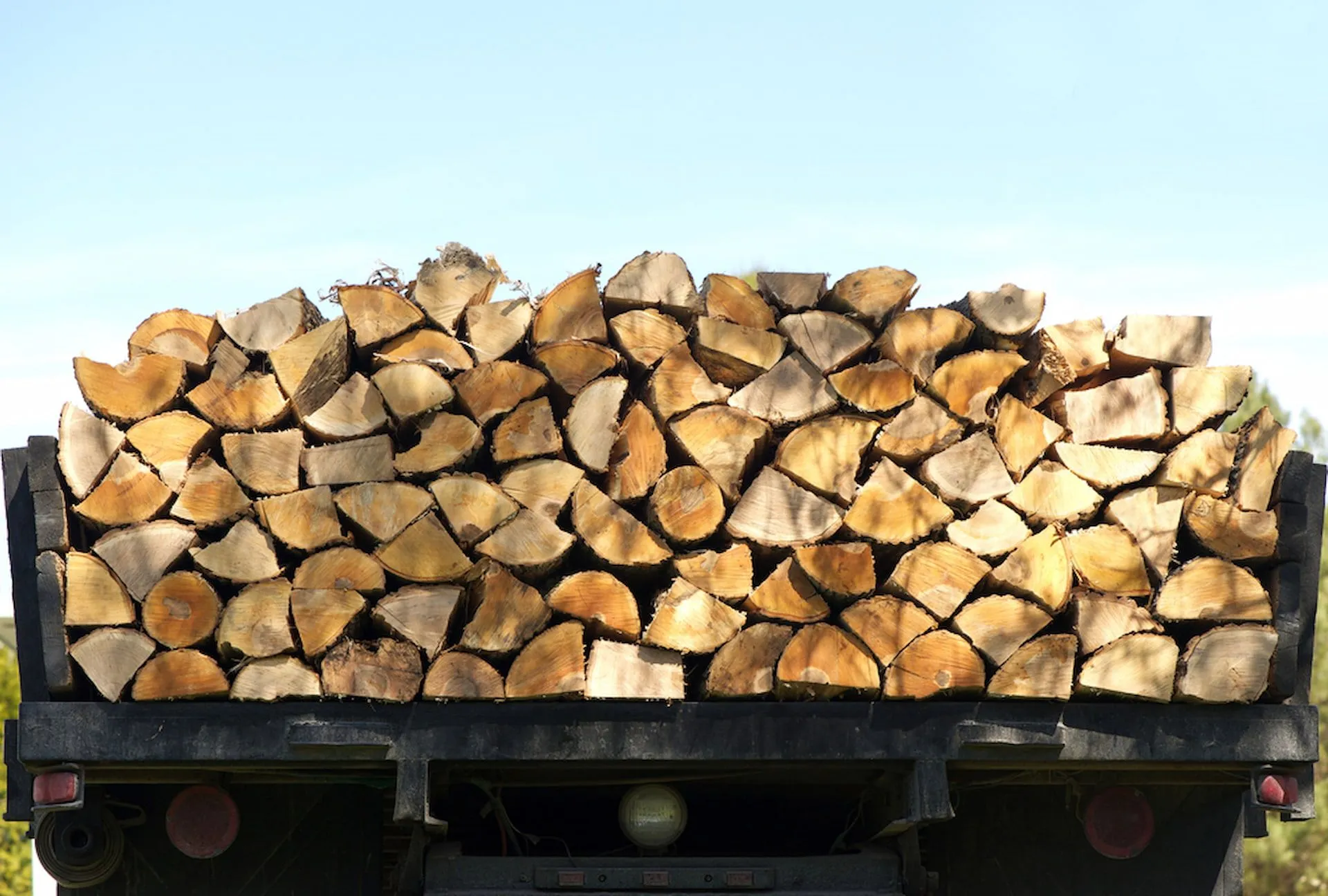 Large delivery load of split firewood stacked on a truck